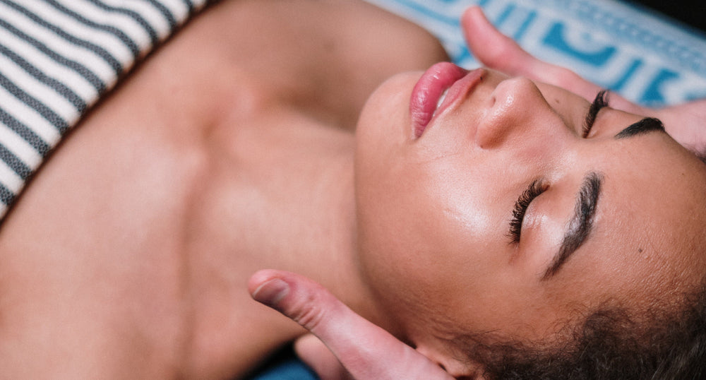 Person receiving a massage on a blue and white patterned mat